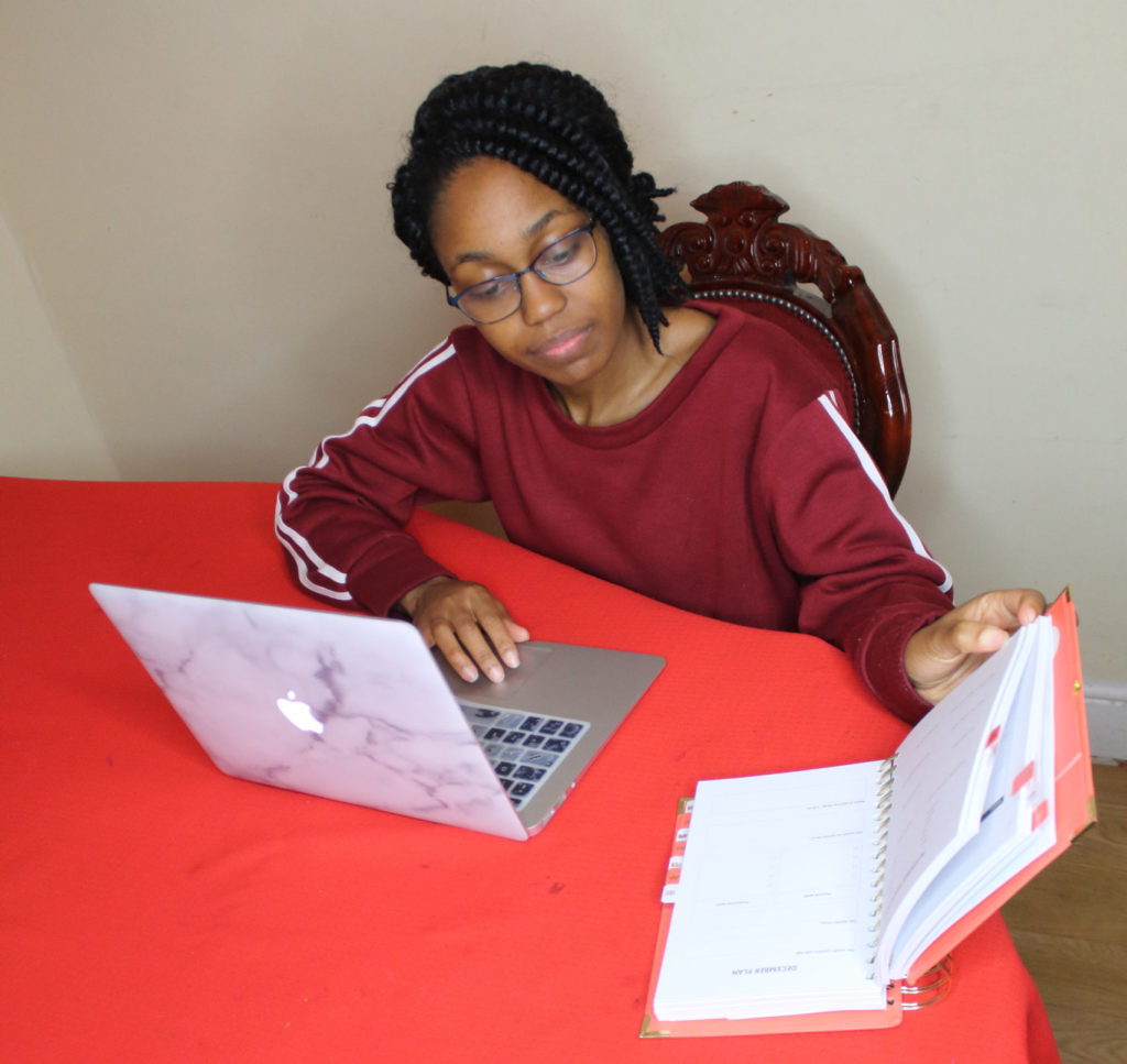 girl looking at notebook with laptop