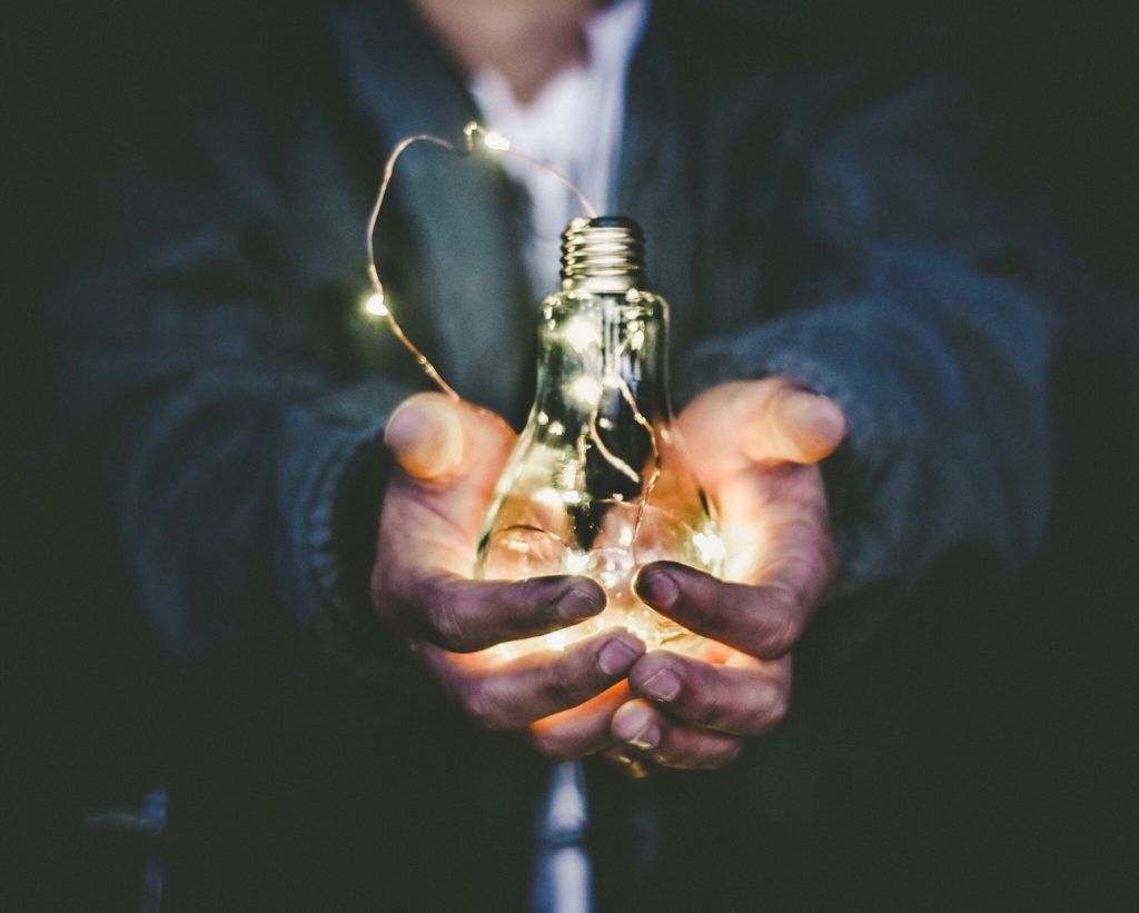 man holding lightbulb signifying idea