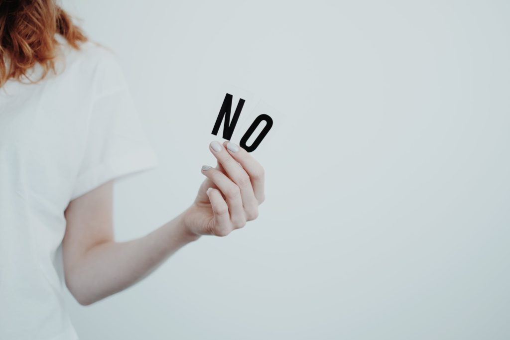 girl holding up sign that says no