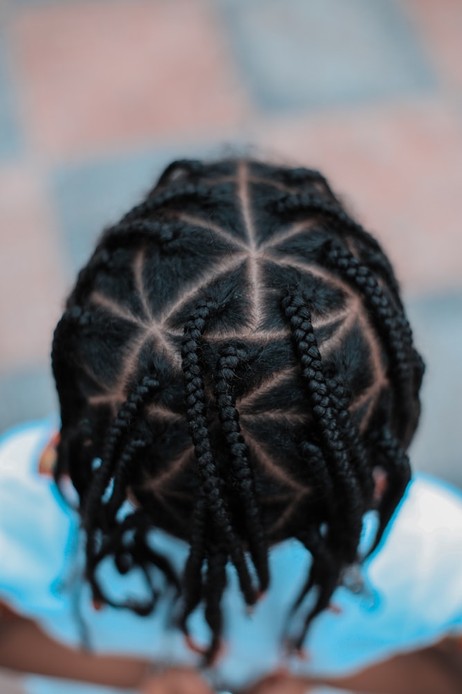 child with long braids on natural hair 